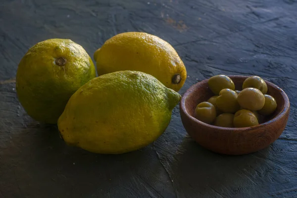 Trois Citrons Une Poupée Pleine Olives Sur Une Table Noire — Photo