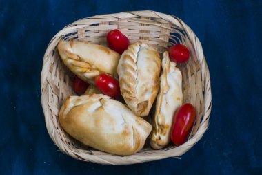 Domatesli bir kasede Empanada. Arjantin geleneksel yemekleri