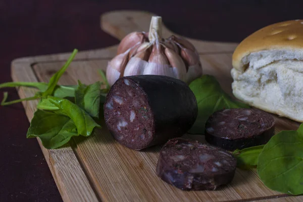 An Argentinian black pudding with a garlic, bread and arugula