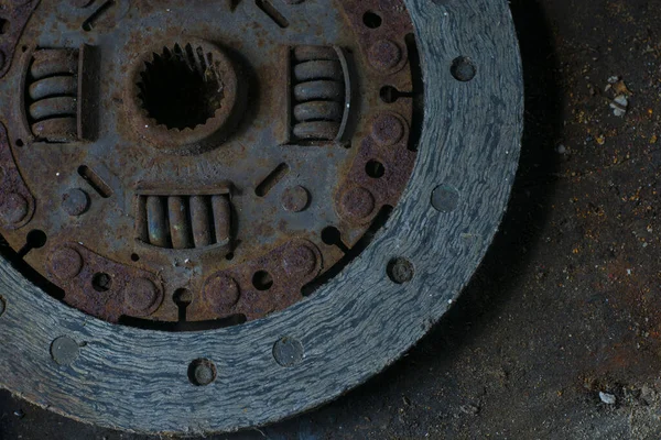 An old basket clutch disk rusty. Automobile part on a dirty table