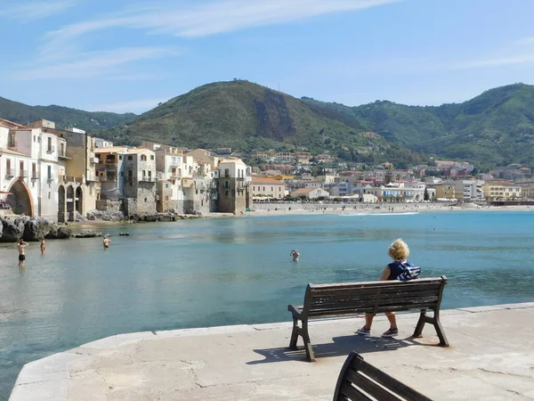 Cefalu, Sicilya, İtalya. 10 Mayıs 2017. Cefalu limanında oturan yaşlı bir kadın.