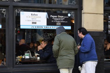Buenos Aires City, Arjantin. 16 Haziran 2018 'de, iki adam bir restoranın penceresinden futbol maçı izlerken 2018' de içki arkadaşı, Arjantin 'de geleneksel bir içki.