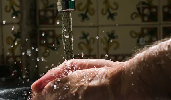 Washing hands under flowing tap. Water splash