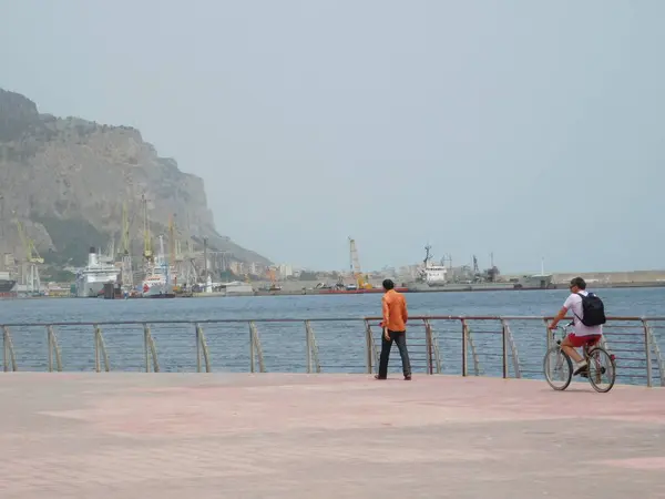 Palermo, Sicilya, İtalya. 11 Mayıs 2017. Palermo 'da parkta bisiklet süren bir adam diğerini gezdiriyor..