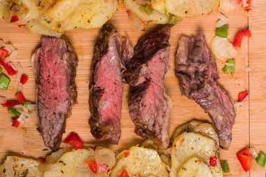 Patatesli Arjantin bifteği, yeşil biber, ahşap bir masada kırmızı biber..