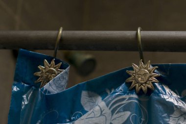 Güneş süslemeli mavi bir banyo perdesi.