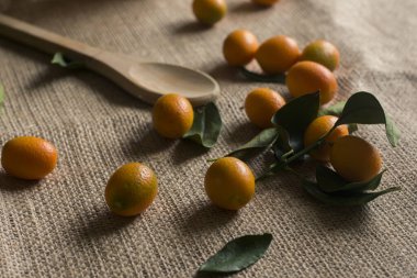 Masada biraz kumkat ve tahta kaşık. Asit meyvesi.