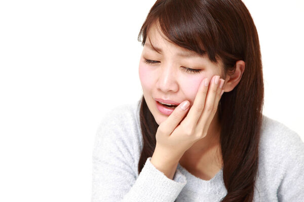 young Japanese woman suffers from toothache
