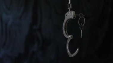 Koyu arka planda anahtar sallanan ile Unlocked kelepçe