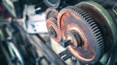 Makinenin eski paslı dişlileri yakın planda..