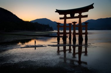 Miyajima 'nın gövdesinin önünde bir kadının silueti. Hiroşima yakınlarında.