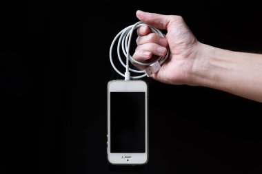 Siyah arkaplanda boş ekranlı akıllı telefon tutan adam. Telefonlu erkek eller, metin için boşluk