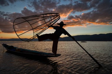 Gün batımında konik ağlarla poz veren Intha balıkçısı, Myanmar Burma 'daki Shan Hills' in Nyaungshwe kasabasında Inle Gölü.
