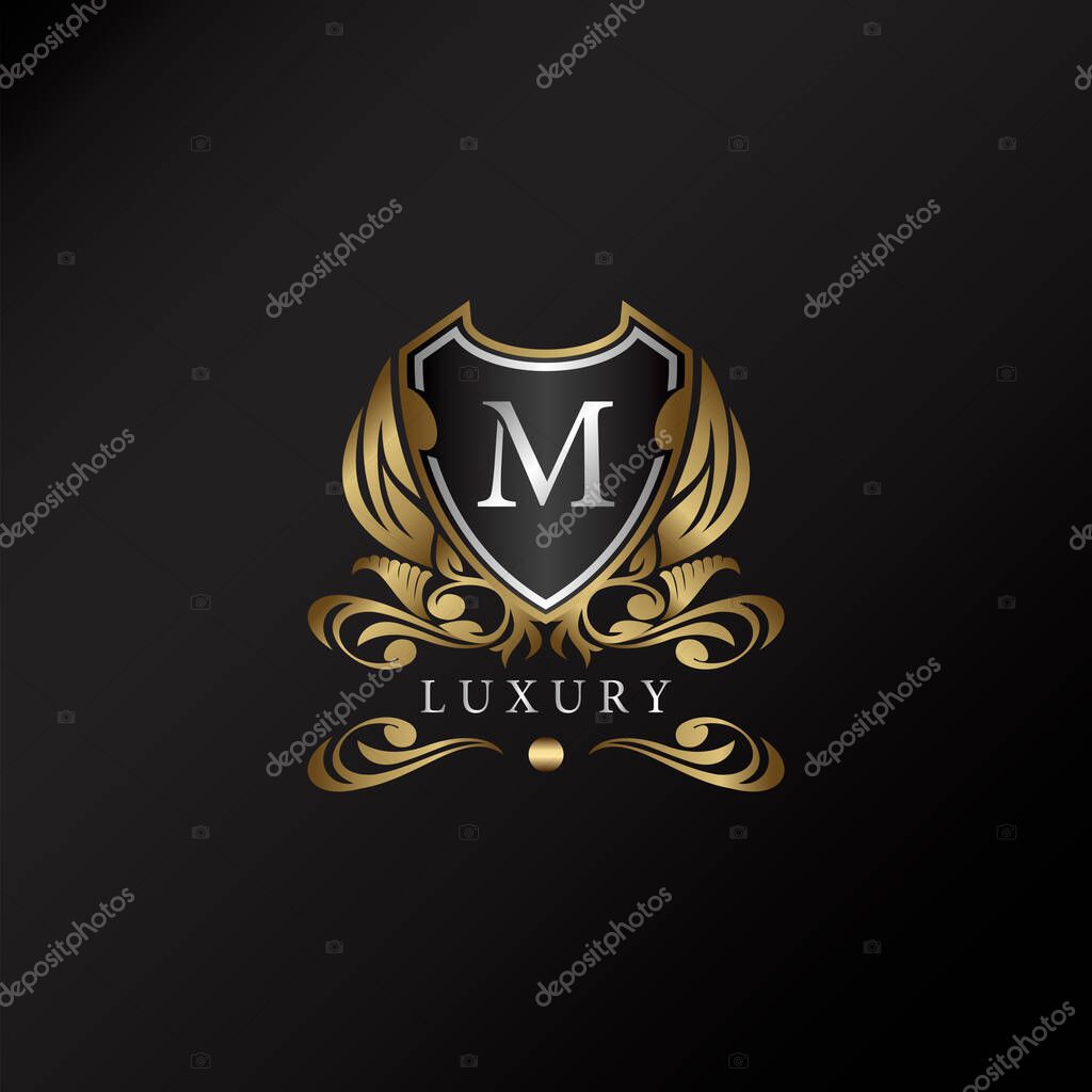 Shield logo in gold color with letter M Logo. Elegant logo vector template made of wide silver alphabet font on shield frame ornate style.