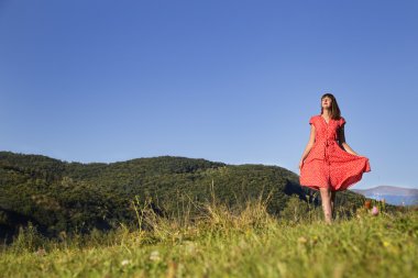 Dağın tepesinde yürüyen güzel genç kız.