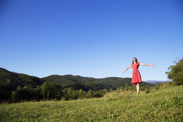 Beautiful young girl walking on mountain top.