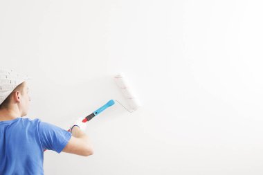 ressam odanın duvarına badanalı.