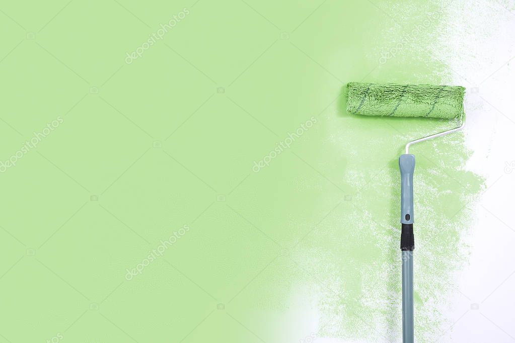 paint roller next to the green wall.