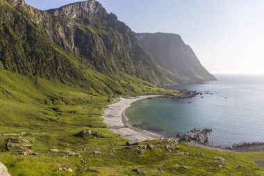 Güzel renk kontrastı. Göz kamaştırıcı bir Norveç plajı, kristal berraklığında okyanus, beyaz kum, yeşil dağlar ve uçurumlar, oraya ulaşmak için inanılmaz bir yürüyüş.