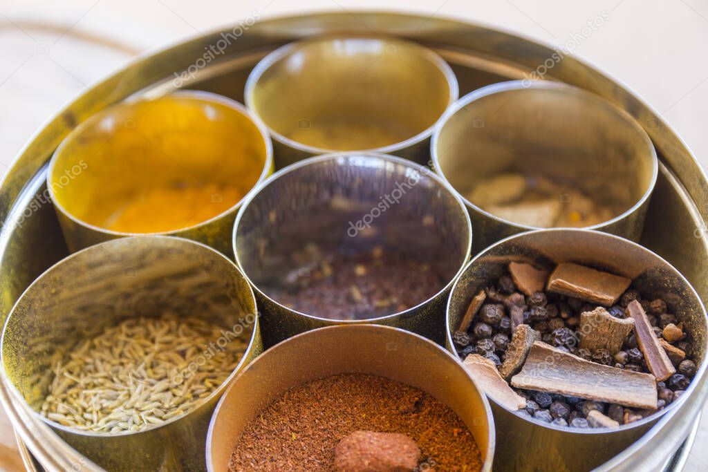 close-up of metal canisters with spices of different colors and textures