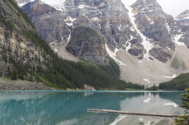 Turkuaz su gölü, karlı tepeleriyle dağları yansıtan bir buzuldan geliyor.