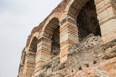 Büyük kemerli pencereleri olan eski bir kumtaşı binanın parçası.