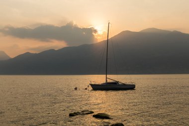 Yelkenli gün batımında gölde yelken açar.