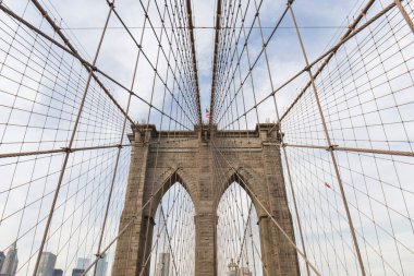 Brooklyn Köprüsü, köprünün içinden fotoğraf, gökyüzünde geometrik şekiller yaratan kemerlerden birinin perspektifi, ABD bayrağını görebilirsiniz, New York 'un fotoğrafları.