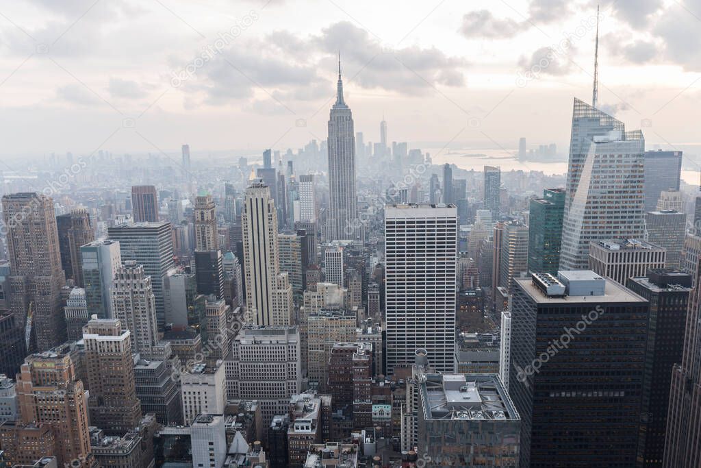 Manhattan skyscrapers seen from the Top of the rock viewpoint in the rockefeller building, hundreds of buildings seen from above, the sky has clouds