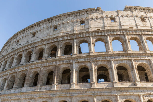 Coliseum or Flavian amphitheatre, Rome, Italy. Part of a Roman construction in very good condition, made of stone with large semi-circular windows, the blue sky is clear
