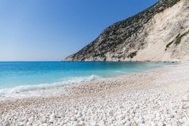Kristal berrak turkuaz su ve beyaz taşlı sahil, Myrtos sahilinde dalgalar, Kefalonia adası, Yunanistan
