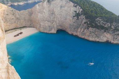 Yunanistan 'ın Zakynthos adasında yelkenli yelkenlisi olan güzel Navagio plajının güzel manzarası. Kayalıklar beyaz kayadan, denizin suyu derin bir mavi ve beyaz kumdan plajdır.