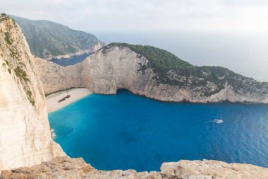 Yunanistan 'ın Zakynthos adasındaki güzel Navagio plajının ideal manzarası. Kayalıklar beyaz kayadan, denizin suyu derin bir mavi ve beyaz kumdan plajdır.