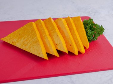 Kırmızı et kıyma tahtasında sarı peynir