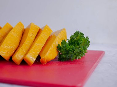 Kırmızı et kıyma tahtasında sarı peynir