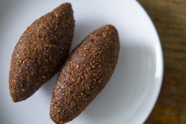 Lezzetli kibbeh frito con salsa de yogur en un bol servido en plato de arcilla sobre una vieja mesa de madera oscura, receta clsica, vista desde arriba, espacio para copiar, plano la la la
