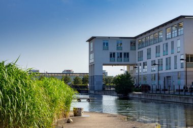 Malmö, İsveç - 9 Ağustos 2017: Suyu ve sazlığı olan bir parkın yanında beyaz bir apartman