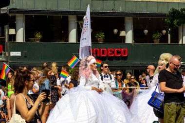 Malmö, İsveç - 20 Temmuz 2019: Beyaz gelinlik giymiş bir travesti İsveç 'in başkenti Malmö' de düzenlenen geçit törenine katıldı..