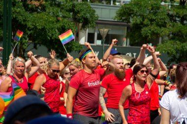 Malmö, İsveç - 20 Temmuz 2019: İsveç 'in Malmö kentindeki geleneksel eşcinsel geçit törenine katılan insanlar kırmızı spor kıyafetlerini giyip, müziğin ritmine ayak uyduruyorlar..