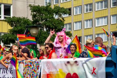 Malmö, İsveç - 20 Temmuz 2019: Bir sürü kadın ve erkeğin parti yaptığı bir tören, ve ortasında pembe giyinmiş bir drag show sanatçısı Malmö, İsveç 'teki yıllık onur yürüyüşü sırasında yumruğunu sallıyor..