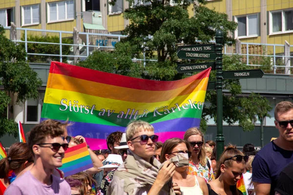 2019年7月20日 瑞典马尔默 参加在瑞典马尔默举行的年度同志骄傲游行的人们举着一面带有 爱大于一切 字样的彩虹色旗帜 — 图库照片