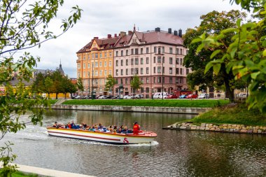 Malmö, İsveç - 2 Eylül 2018: Rundan gezi teknesinin yarısı turist dolu, rehber onlara kanal boyunca uzanan parklar ve eski binalar hakkında bilgi veriyor