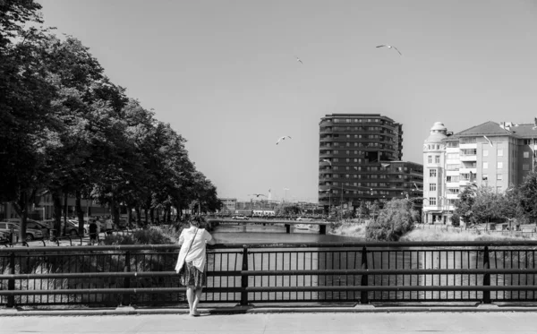 スウェーデンのマルモ 2018年7月8日 50代の孤独な女性が運河の上の橋の上に立って人々を迂回するのを見ています モノクローム — ストック写真