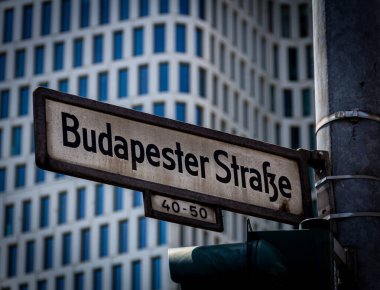 Alman ismi Budapester Strasse olan bir sokak tabelasının yakın plan fotoğrafı, Berlin, Kurfurstendamm adlı şehir merkezindeki bir sokak lambasına monte edildi.