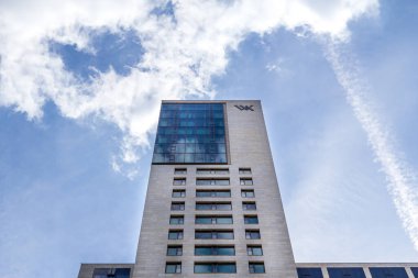 Berlin, Almanya - 30 Mayıs 2019: Gökdelen Zoofenster mavi gökyüzüne doğru yükseliyor. Waldorf Astoria 'nın amblemi bir otele ev sahipliği yaparken ön cepheye monte edilmiştir..