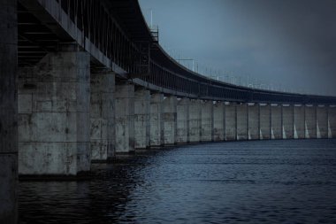 İsveç 'in Malmö kentinde, karanlık bir deniz kıyısında köprüyü ayakta tutan beton sütunlar.