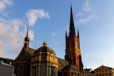 Riddarholmskyrkan (Riddarholm Kilisesi), Stockholm 'de büyük bir katedraldir. Çan kulesi yaz akşamı güneşinde parlıyor.