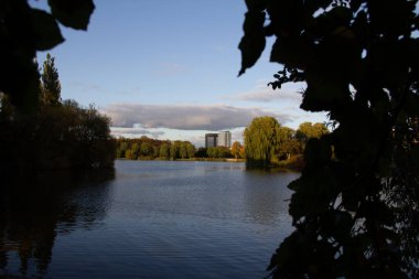 Malmö, İsveç - 5 Ekim 2019: Bunlardan biri Scandic Otel 'de olmak üzere iki yüksek bina, Pildammsparken adlı sonbahar renkli parkın ötesinden görülebiliyor.