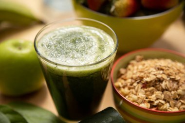 Böğürtlen ve tahıllı cam bardakta yeşil smoothie.