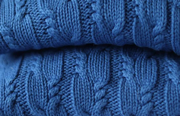Seamless knitted fabric with pigtails. Knitted sweater, plaid, scarf. Knitted background. Classic Blue color 2020